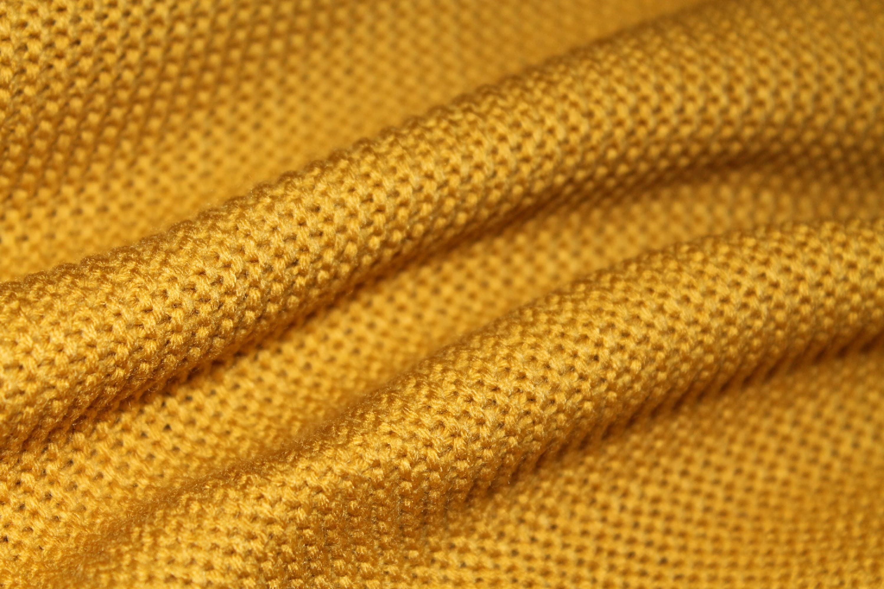 Close-up of golden woven fabric arranged in folds